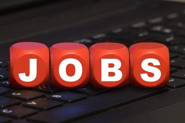 Rote Würfel mit dem Schriftzug „JOBS“ auf einer schwarzen Laptop-Tastatur.